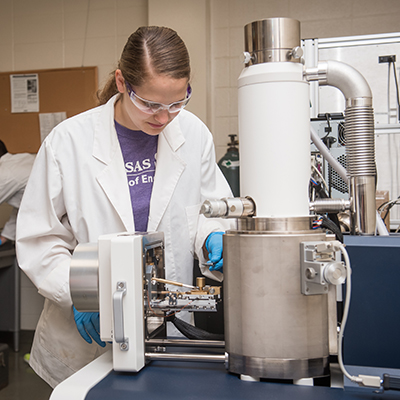 Graduate student working with equipment in a lab
